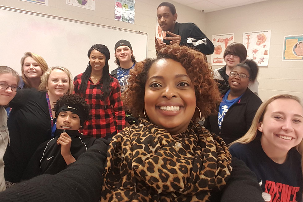 teacher and students smiling at camera