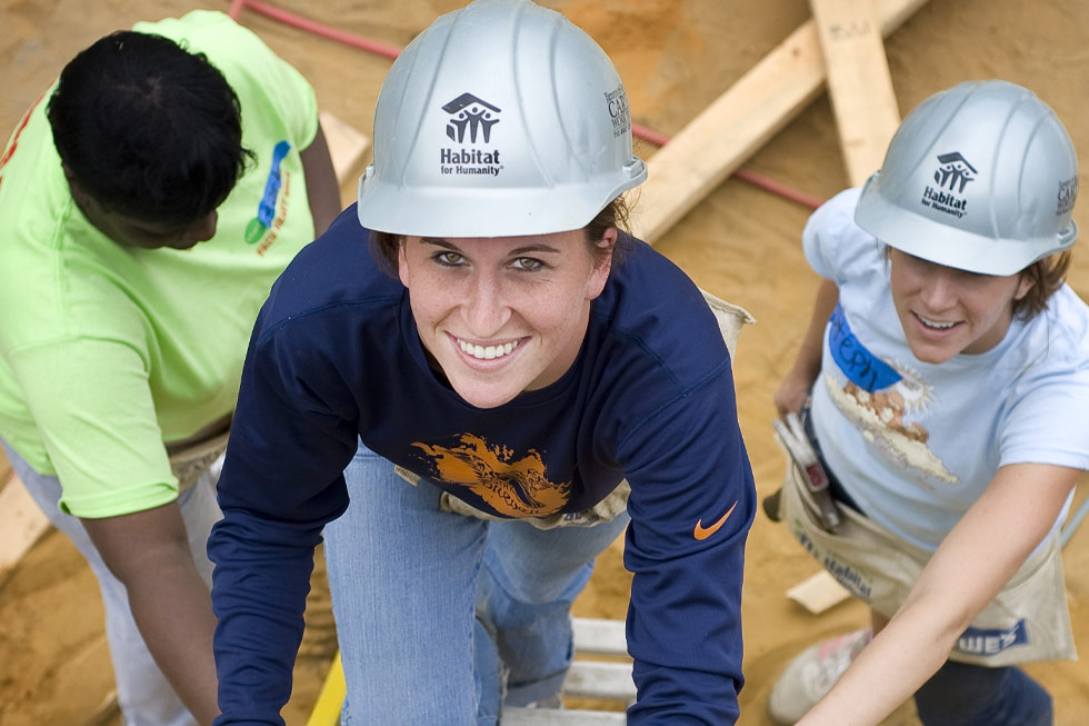 Worker climbing up ladder and smiling at camera